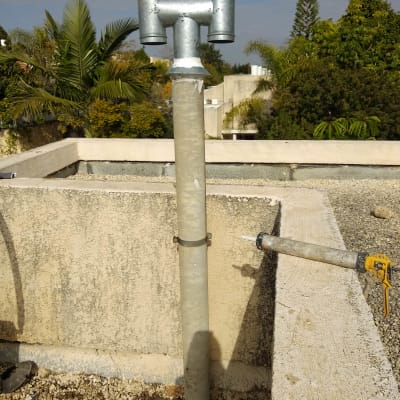 צינור מתכת על גג עם חומר איטום סביבו