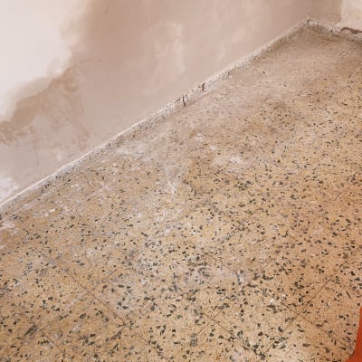 קיר עם סימני רטיבות ורצפה מרוצפת