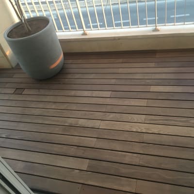 רצפת עץ עם עציץ גדול במרפסת