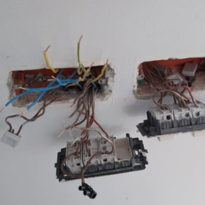 חוטי חשמל חשופים בקיר עם מתגי חשמל