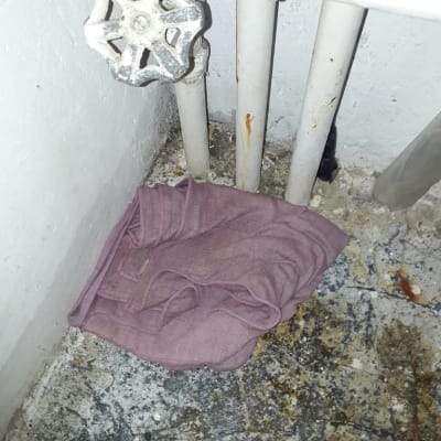 ברז ישן עם צינורות חלודים ומטלית סגולה