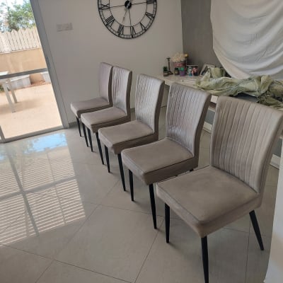 חמישה כיסאות מרופדים מסודרים בשורה בחדר מואר