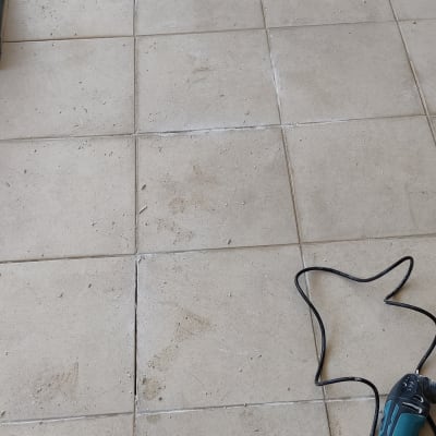 כלי עבודה חשמלי על רצפה עם אריחים שבורים