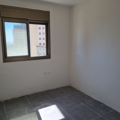 חדר עם רצפת אריחים חדשים ונורה חשופה