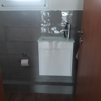 כיור חדש עם ברז כסוף על רקע אריחים אפורים