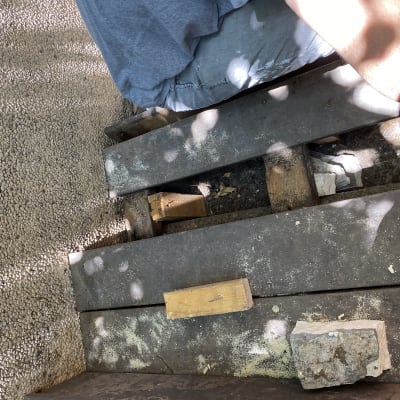 אדם יושב על קרשים עם עץ ואבנים