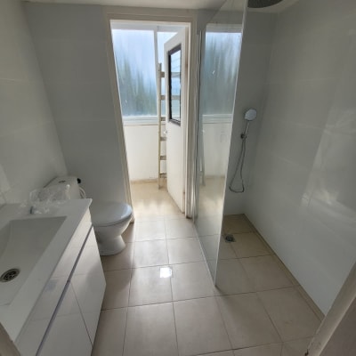 חדר אמבטיה עם מקלחון חדש, כיור ושירותים