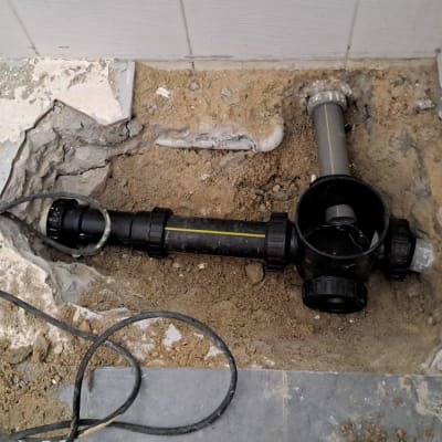 צינור ביוב שחור עם חיבורים בתיקון רצפה