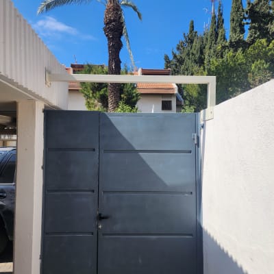 שער מתכת כחול עם מסגרת לבנה