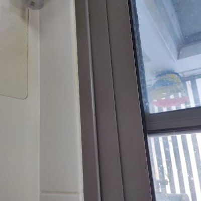 ברז מתכת ליד חלון עם מסגרת אפורה