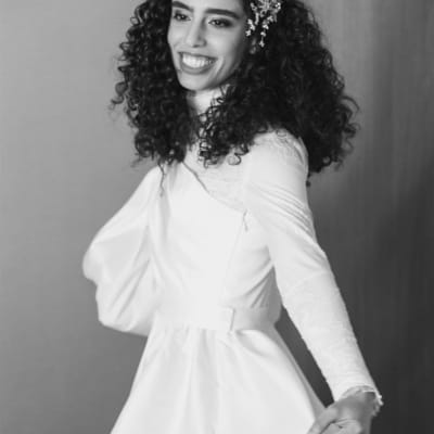 אישה עם שיער מתולתל וקישוט פרחים בשיער