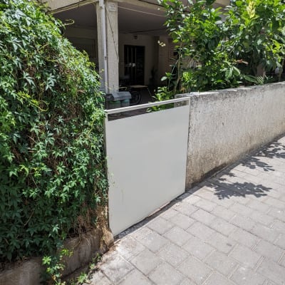 שער לבן קטן בכניסה לחצר