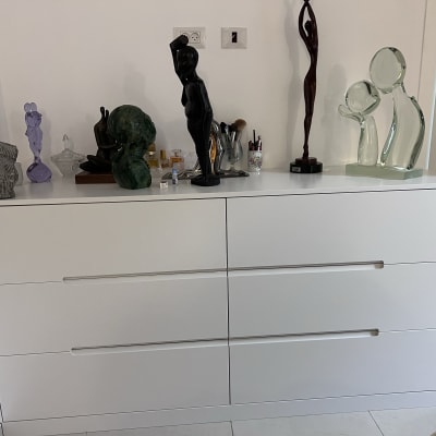 שידה לבנה עם פסלים וחפצי נוי