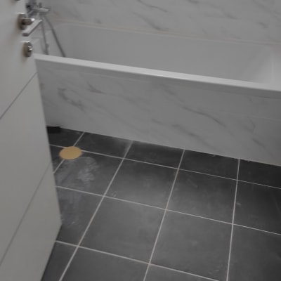 אמבטיה עם רצפה כהה וכתם על הרצפה