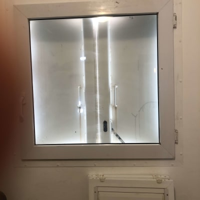 חלון עם מסגרת לבנה וקיר לבן