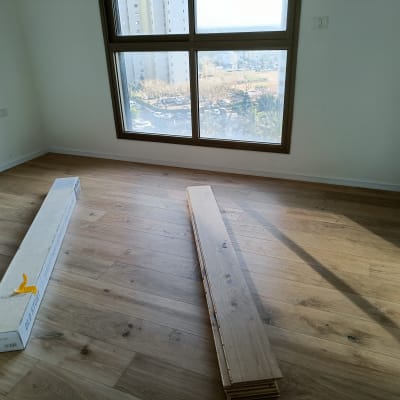 חדר עם פרקט עץ וקופסת פרקט על הרצפה