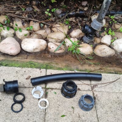 חלקי צנרת פלסטיק שחורים ואביזרי חיבור על רצפה