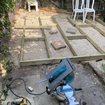 מסגרת עץ על חצץ עם מסור חשמלי וכלים נוספים