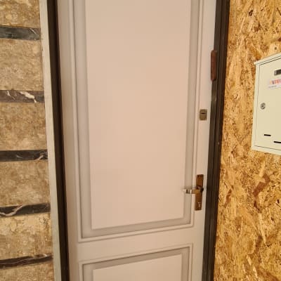 דלת מתכת עם ציפוי לבן ומסגרת כהה