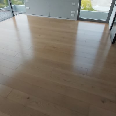 רצפת עץ נקייה בחדר עם חלונות גדולים