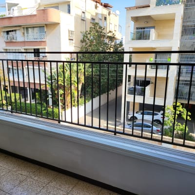 מעקה ברזל שחור במרפסת עם חלון פתוח