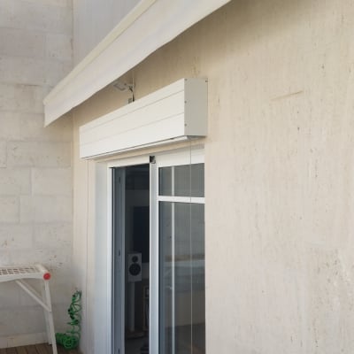 סוכך לבן מותקן מעל דלת זכוכית