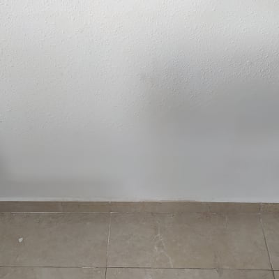 קיר צבוע בלבן עם שקע חשמל מימין