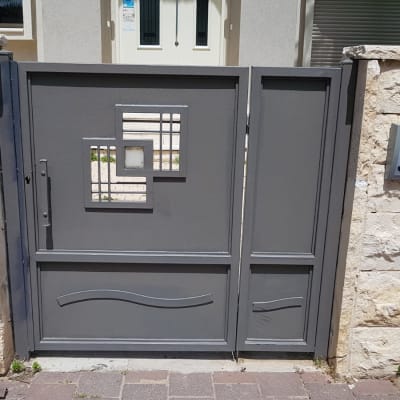 שער מתכת אפור עם עיצוב גיאומטרי במרכז