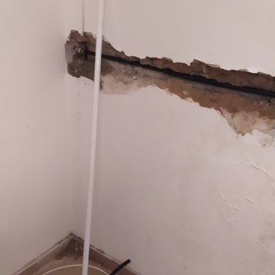 צינור חשוף בקיר עם כלי עבודה על הרצפה