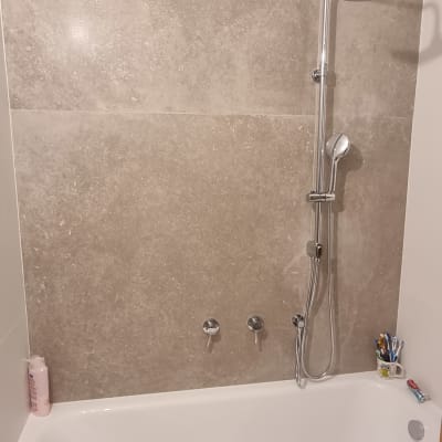 אמבטיה עם אריחים חדשים ומקלחת מותקנת
