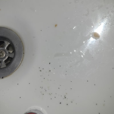 כיור עם לכלוך ומים סביב פתח הניקוז