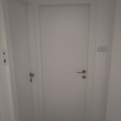 דלתות לבנות עם ידיות מתכת על קיר לבן