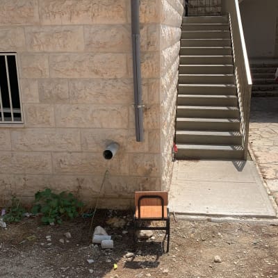 צינור ביוב אפור מחובר לקיר אבן חיצוני