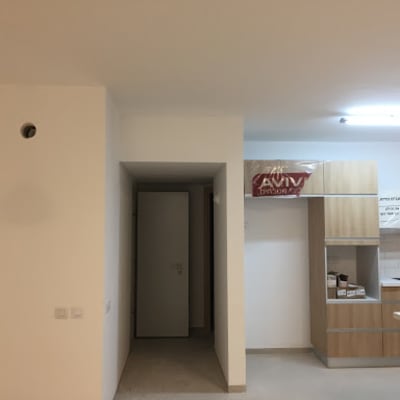 קיר גבס לבן עם חור עגול ותאורה תלויה