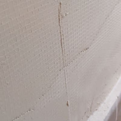 קיר עם סדקים ורשת תיקון לפני צביעה