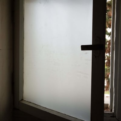 חלון זכוכית חלבית פתוח עם מסגרת מתכת