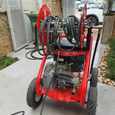 מכונת שטיפה בלחץ עם צינור על גלגלים