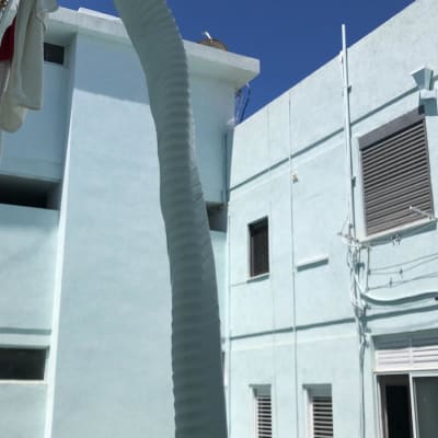 צינור מיזוג אוויר לבן תלוי מחוץ לבניין