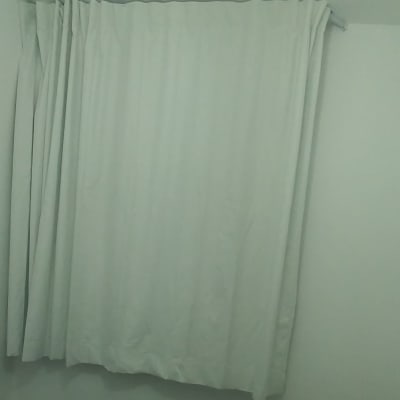 וילון לבן תלוי על קיר לבן בחדר