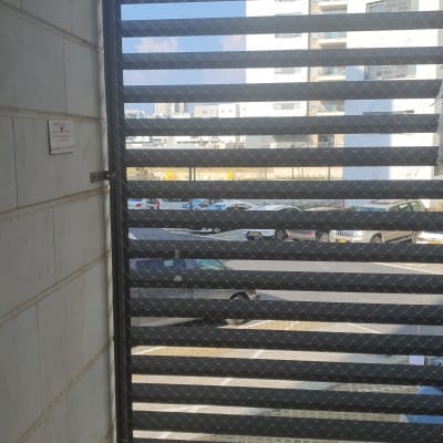 רשת מתכת מותקנת על חלון למניעת כניסת יונים