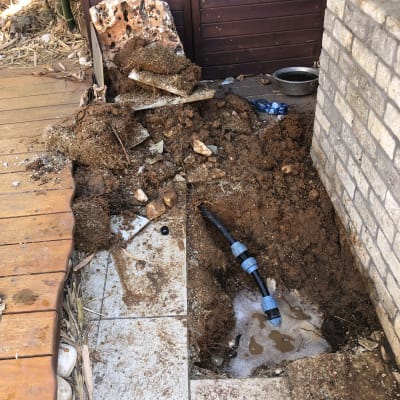 צינור מים חשוף באדמה עם חיבורים