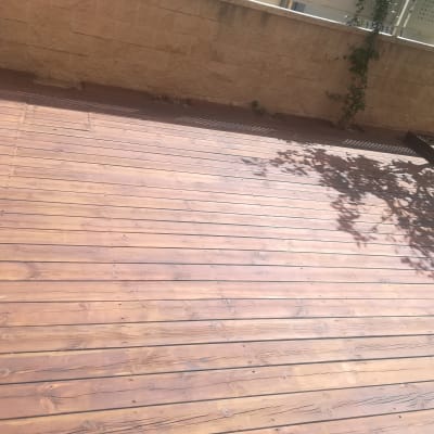 דק עץ בגינה עם צל עץ על הרצפה