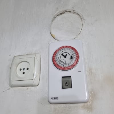 שקע חשמל וטיימר על קיר לבן