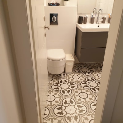 חדר אמבטיה עם אריחים מעוצבים ושירותים מודרניים