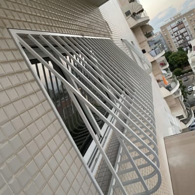 סורגי מתכת לבנים על חלון בניין