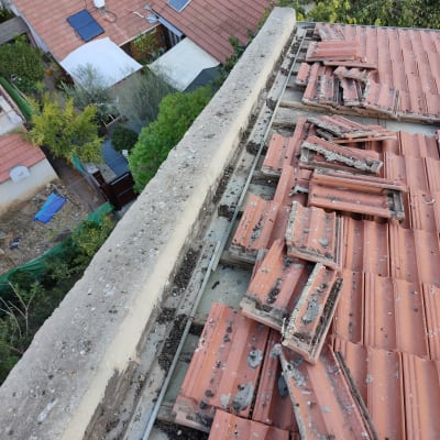רעפים שבורים על גג רעפים אדום עם לכלוך