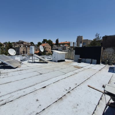 גג עם יריעות איטום לבנות וציוד טכני