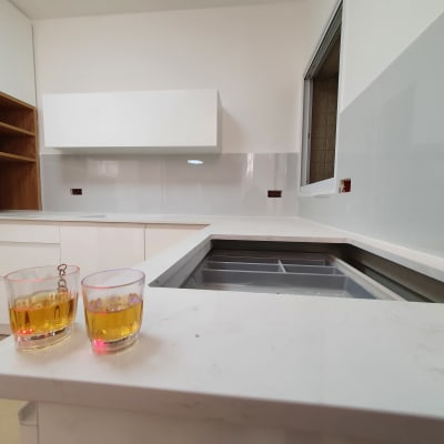 מטבח חדש עם ארונות לבנים ומשטח עבודה