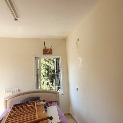 קיר צבוע בצבע בהיר עם סימני תיקון