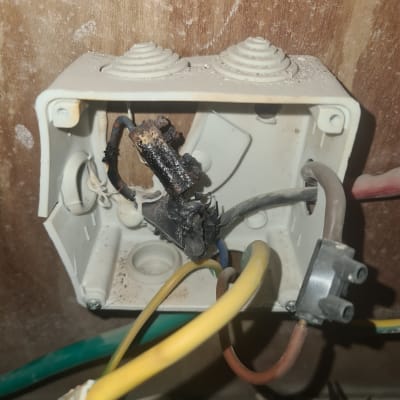 חוטי חשמל שרופים בתיבת חיבורים פתוחה